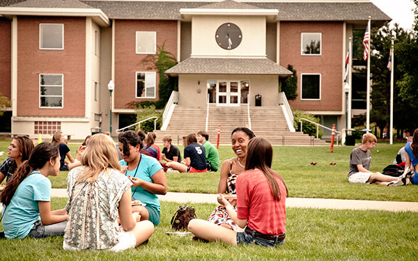 students sitting on quad in front of library