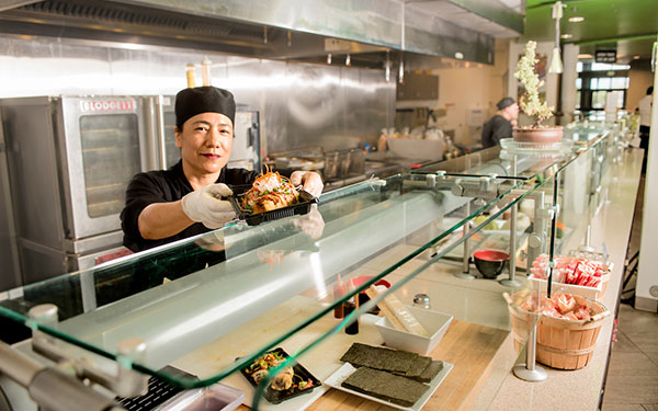 a chef in the main cafe presents her fresh-made sushi