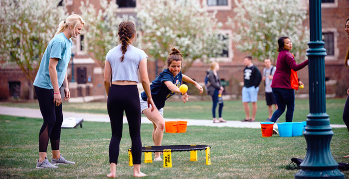 students play spikeball outdoors