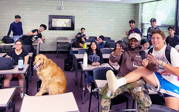 first-gen students and a yellow lab sit in a classroom during a meeting of their ILC in Loyola Hall