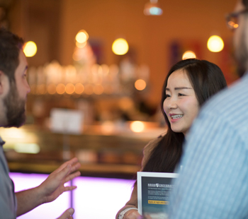 Three people interacting together at admissions event