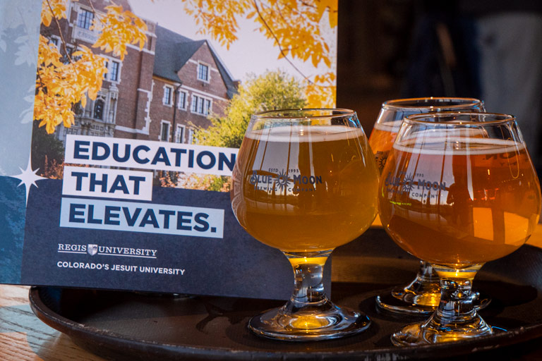 Education that elevates booklet on the left side. Blue Moon glasses on the right.