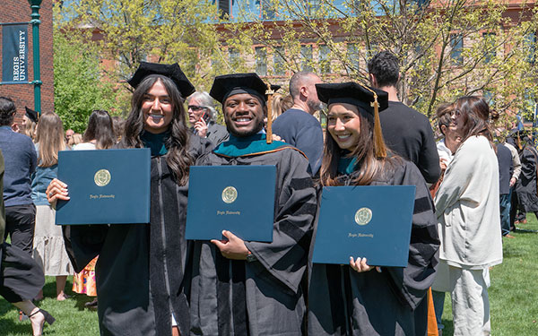 three doctoral grads proudly display their new diplomas following commencement ceremonies on the Northwest Denver campus