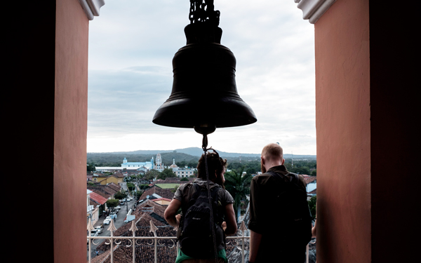 two male students overlooking an international city from a bell tower