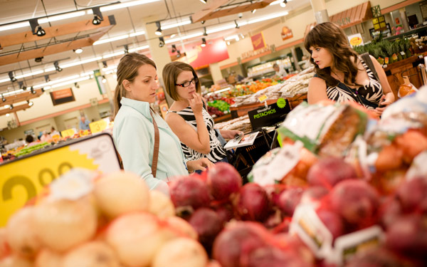 Two people at a grocery store in the produce aisle