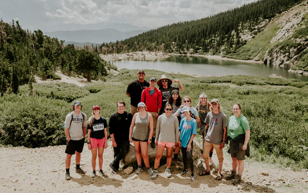 Group of students standing together in the mountains on a trail