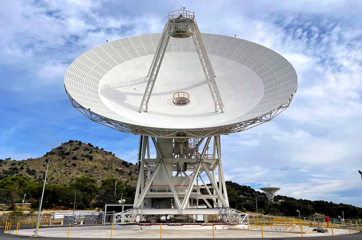 Deep Space Station 53 (DSS-53), a 34-meter-wide beam waveguide antenna at NASA's Deep Space Network ground station in Madrid, shown against a backdrop of a clear sky and nearby hills. 