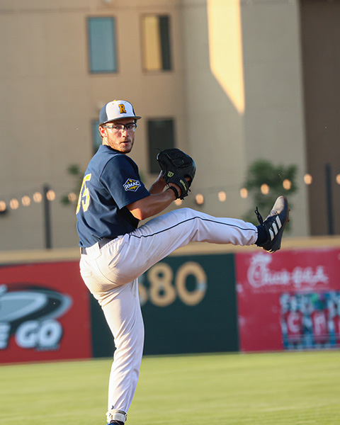 Ethan Sloan winds up to pitch a baseball