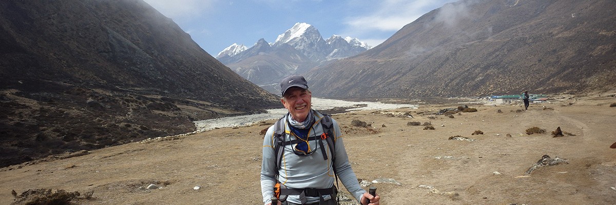 Roger Pomainville stands in a valley between mountains