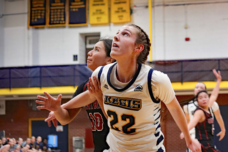 Sam Deem looking up for the basketball while boxing out another player