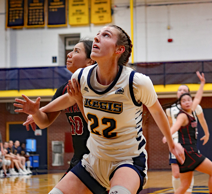 Sam Deem looking up for the basketball while boxing out another player