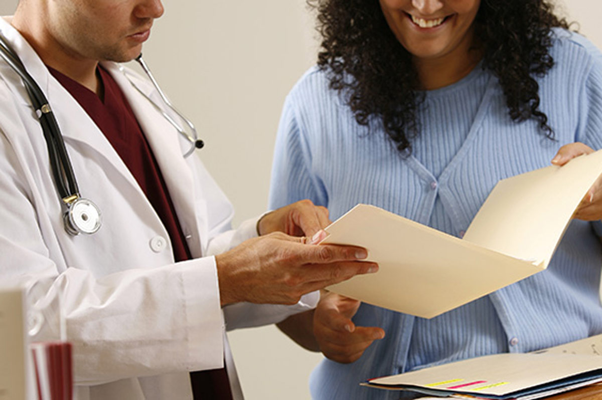 A physician and a hospital administrator review a patient file together. 