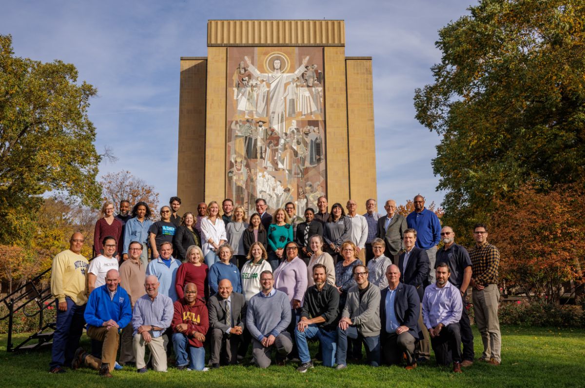 Group of people posed in front of a monument of Jesus Christ