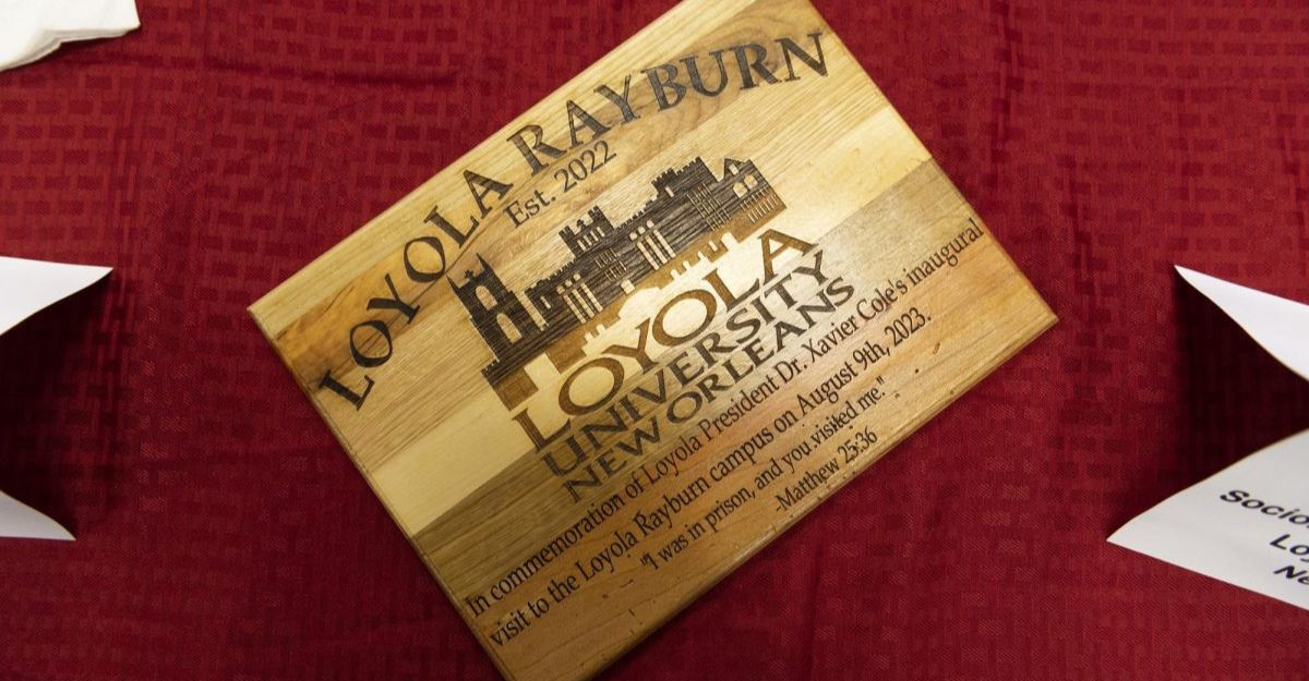 Photo of a wooden plaque commemorating the opening of the Loyola Universitys Prison Education Program in Rayburn, LA.