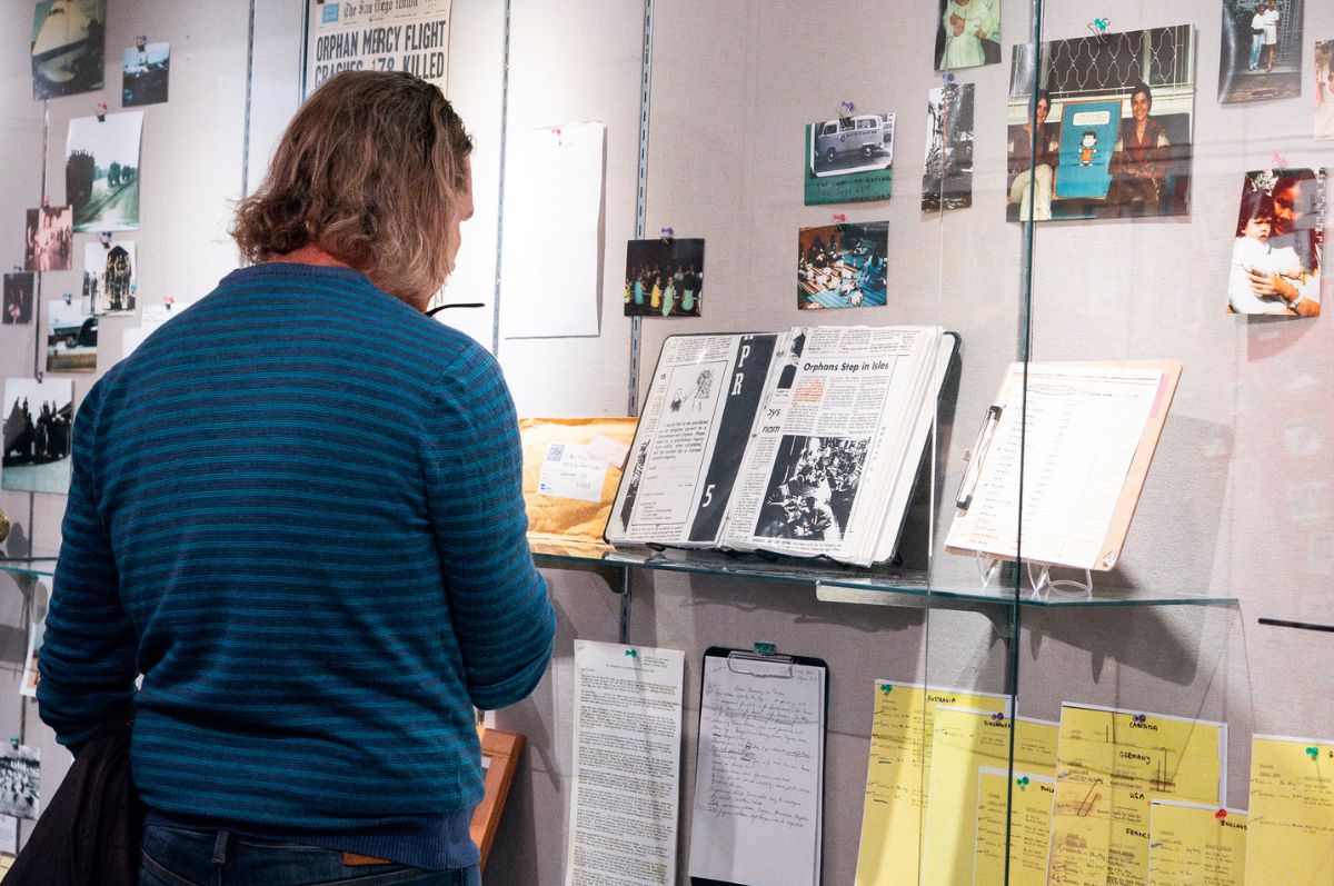 Shot of the Operation Babylift: New Perspectives exhibit with a visitor viewing the documents