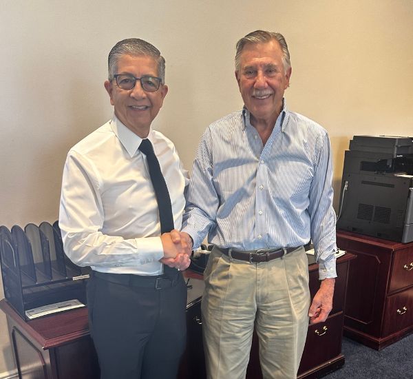 President Salvador D. Aceves and Roger Pomainville shaking hands