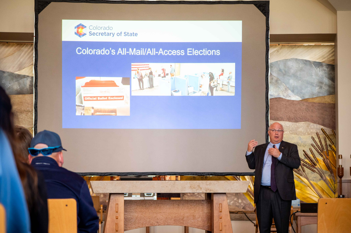 Colorado Deputy Secretary of State Chris Beall speaks in front of screen